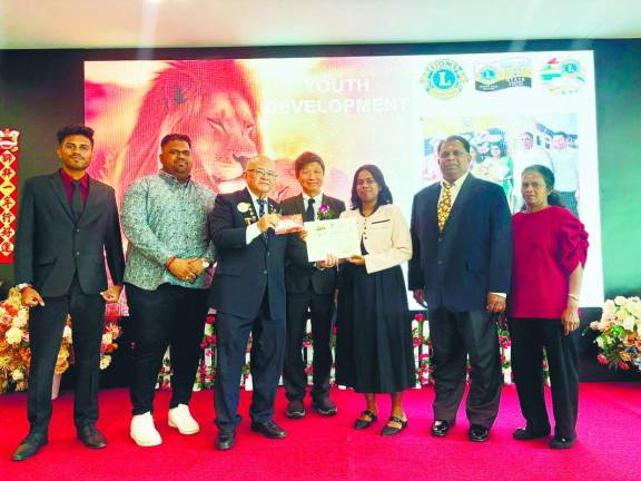 Ng presenting the bursary and certificate to Sarmili for her STPM achievement.
