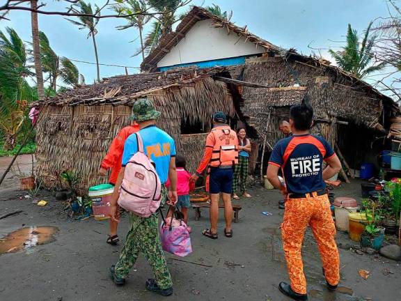 This handout photo taken on November 14, 2024 and released by Buguey Municipal Disaster Risk and Reduction Management Office via Cagayan Provincial Public Information office shows rescuers fetching residents during a forced evacuation operation in Buguey town, Cagayan province, north of Manila, ahead of Super Typhoon Usagi's landfall. The Philippines raised its highest storm alert and evacuated thousands of people on November 14, as Super Typhoon Usagi barrelled towards its already disaster-ravaged north. - AFP PHOTO / BUGUEY MUNICIPAL DISASTER RISK AND REDUCTION MANAGEMENT OFFICE VIA CAGAYAN PROVINCIAL PUBLIC INFORMATION OFFICE