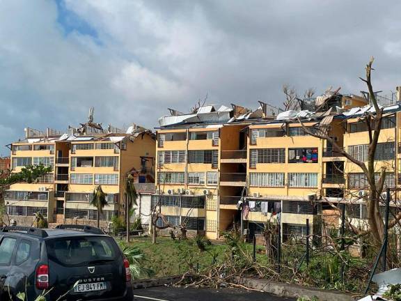 A photo taken on December 15, 2024 shows torn-off roofs of residential buildings after the cyclone Chido hit France’s Indian Ocean territory of Mayotte. At least 14 people were killed in Mayotte when a fierce cyclone battered the French Indian Ocean territory, authorities said on December 15, 2024, with officials warning it will take days to know the full toll. - KWEZI / AFP