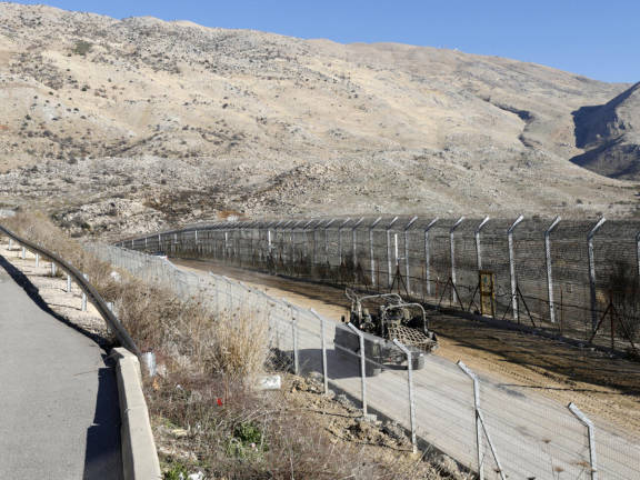 An Israeli army vehicle patrols near the fence leading into the UN-patrolled buffer zone separating Israeli and Syrian forces on the Golan Heights. - AFPpix