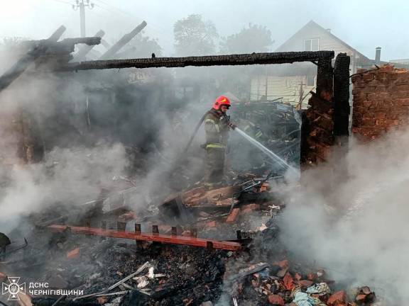 In this handout photograph taken and released by the Ukrainian Emergency Service on June 5, 2025 a rescuer extinguishes a fire following a drone strike in Pryluky, Chernihiv region, amid the Russian invasion of Ukraine. - AFP PHOTO /UKRAINIAN EMERGENCY SERVICE
