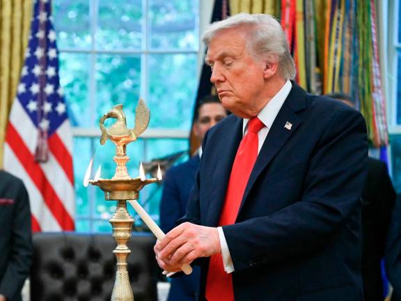 US President Donald Trump lights a candle during a Diwali celebration with American Indian leaders in the Oval Office of the White House in Washington, DC, on October 21, 2025. - AFP pic