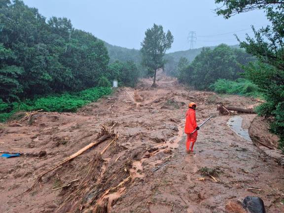 A firefighter stands on the soil after a landslide caused by torrential rains, in Sancheong, South Korea, July 19, 2025. Yonhap via REUTERS THIS IMAGE HAS BEEN SUPPLIED BY A THIRD PARTY.