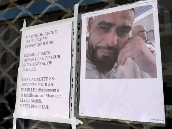 A notice at the salon where Hichem Miraoui worked advertises an anti-racist march. His alleged killer reportedly posted racist videos on social media. - AFPpix