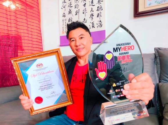 Wee showing his MyHero award and ‘Ambassador of Unity’ certificate. – PIX COURTESY OF PETER WEE