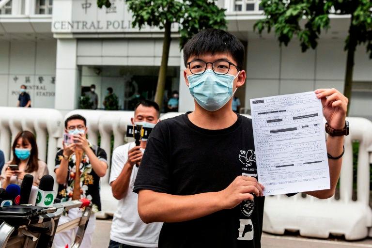 Pro-democracy activist Joshua Wong speaks to the media after being bailed following his arrest for unlawful assembly related to a 2019 protest against a government ban on face masks. — AFP