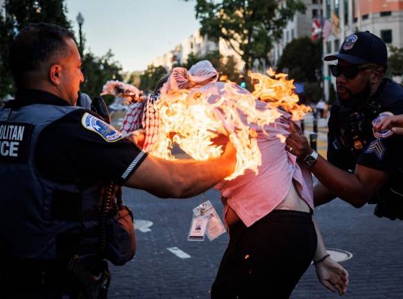 Police help a man who tried to set himself on fire as people demonstrate to mark one year of the war between Hamas and Israel near the White House in Washington, DC, on October 5, 2024. - Ting Shen / AFP