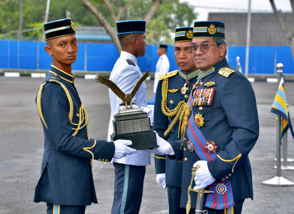 The Chief of the Air Force, General Tan Sri Mohd Asghar Khan Goriman Khan (right), presents the Chief of the Air Force Trophy (Best Overall Fixed-Wing Trainee) to Lt Muhammad Irfan Salmi RMAF (left) during the Wing Presentation Parade for the Basic Flying Course Series 86/24 and the Basic Helicopter Flying Course Series 66/24 at the Air Force College today. - BERNAMA