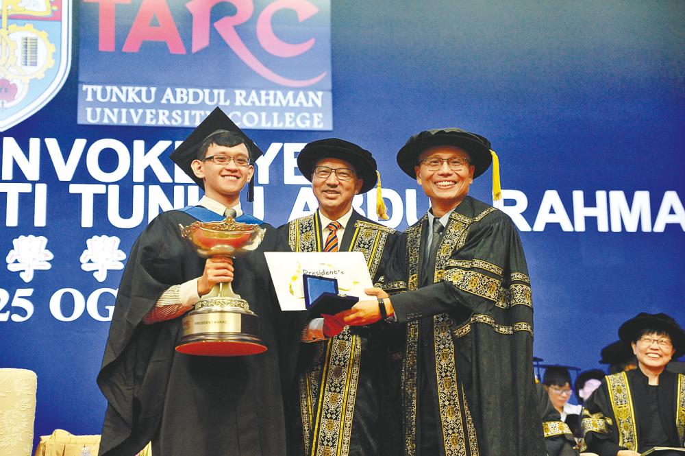 Prof Dr Lee Sze Wei (right), President of TAR UC, presenting the trophy, certificate and token of appreciation to Ong Kevin (left), the President’s Award winner while Liow witnesses the exchange.