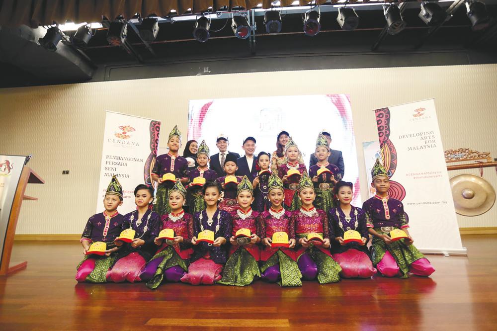 Maszlee (standing, centre) with the performers from Genius Seni Tari.