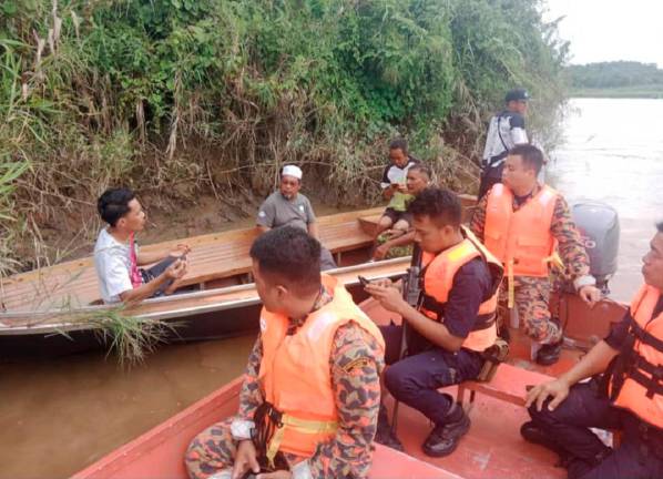 Officials and villagers searching for the victim following the crocodile attack in remote Sungai Pandam. - Sarawak Bomba pic