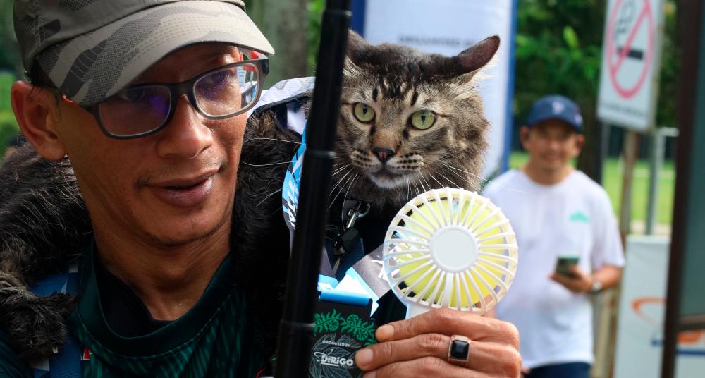 $!Jibek, the most famous cat in the running community, with owner Apak (left).