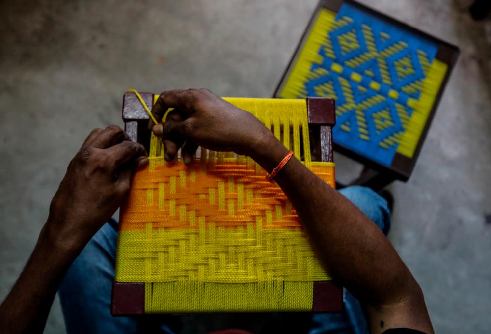 $!It takes Saravanan four to nine hours to complete each stool. “Weaving is like reading in Braille,” he said.