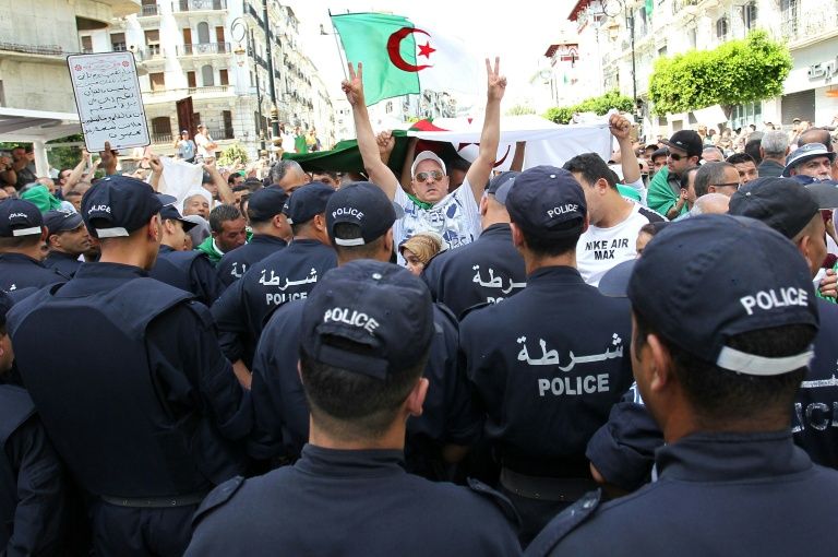 Algerian protesters face riot police during a demonstration in the capital Algiers in June. — AFP