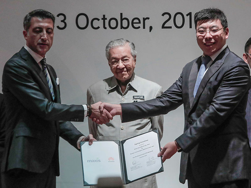 Prime Minister Tun Dr Mahathir Mohamad (C) witnesses the signing of an agreement for the provisioning of the 5G, between Maxis CEO, Gokhan Ogut (L), and Huawei CEO, Michael Yuan, at the Perdana Leadership Foundation, on Oct 3, 2019. — Sunpix by Ashraf Shamsul