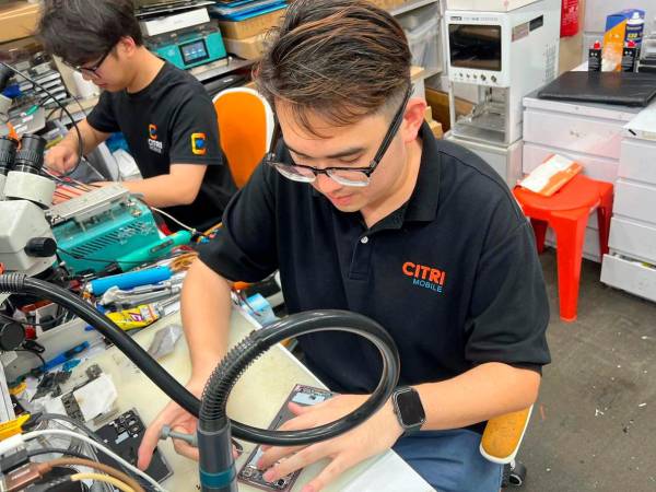 A Citri Mobile technician performing internal diagnostics at a fully equipped repair station in Singapore.