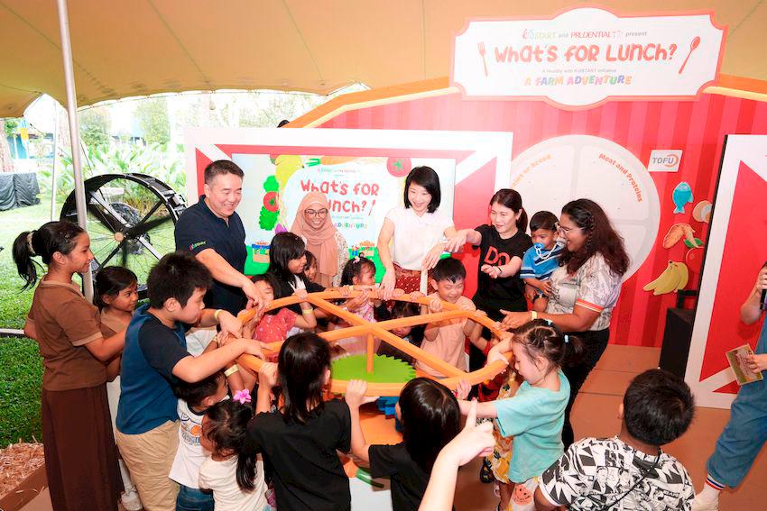 (From left) Mr Joel Tan, Chief Executive Officer of KidSTART Singapore, KidSTART mother Ms Nur Farah, Ms Sun Xueling, Minister of State for Social and Family Development, Ms Chan San San, Chief Executive Officer of Prudential Singapore, and KidSTART mother Ms Sangeetha D/O Jagathisa, join more than 600 parents and children at the What’s for Lunch? A Farm Adventure food expo, at The Lawn @ The Foothills, Fort Canning Park.