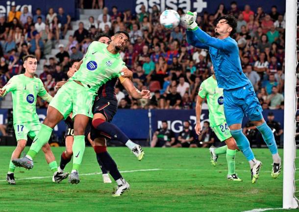 Barcelona’s Uruguayan defender Ronald Federico Araujo da Silva challenges Levante’s Spanish goalkeeper Pablo Campos during the Spanish league football match between Levante UD and FC Barcelona at Ciutat de Valencia Stadium in Valencia. - AFP