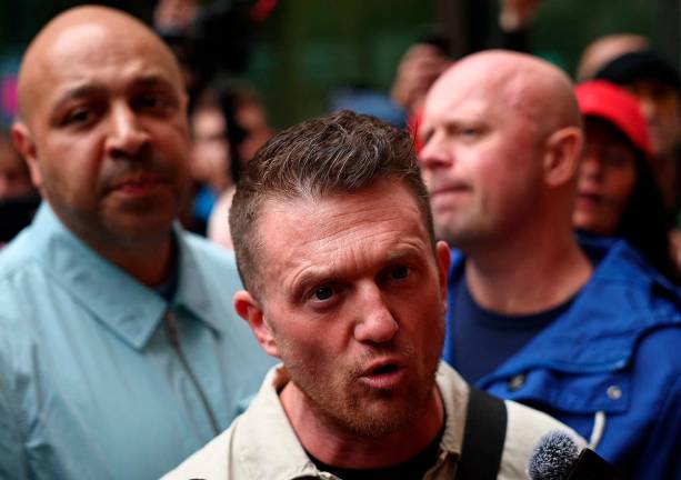 British far-right activist Tommy Robinson, whose real name is Stephen Yaxley-Lennon, speaks to media as he leaves Westminster Magistrates’ Court in London on June 5, 2025, where he appeared charged with “harassment” of two journalists. Robinson was freed from prison last week after winning his plea for early release after being convicted of contempt of court. - HENRY NICHOLLS / AFP