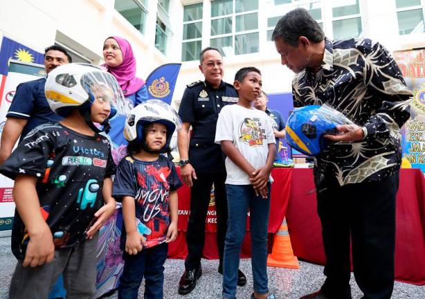 Pengerusi Majlis Keselamatan Jalan Raya Kedah, Dzowahir Ab Ghani memakaikan topi keledar kepada kanak-kanak yang menyertai aktiviti diadakan Jabatan Pengangkutan Jalan (JPJ) sebelum merasmikan sambutan Hari Memperingati Mangsa Kemalangan Jalan Raya Sedunia 2024 peringkat negeri di Hospital Sultanah Bahiyah, hari ini. - fotoBERNAMA