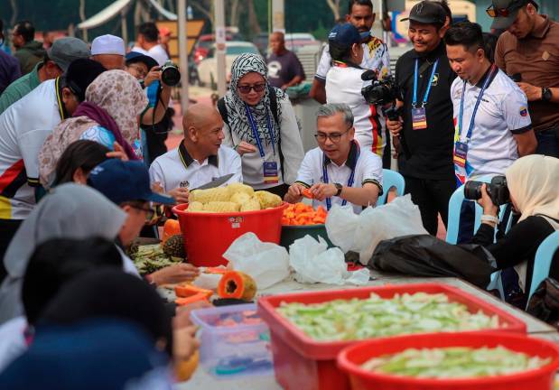 Communications Minister Datuk Fahmi Fadzil and Domestic Trade and Cost of Living Minister Datuk Armizan Mohd Ali spent time working together and helping out with the residents of Kampung Pachitan, Port Dickson, Negeri Sembilan to prepare food for the Kenduri Rakyat programme - Bernama pic