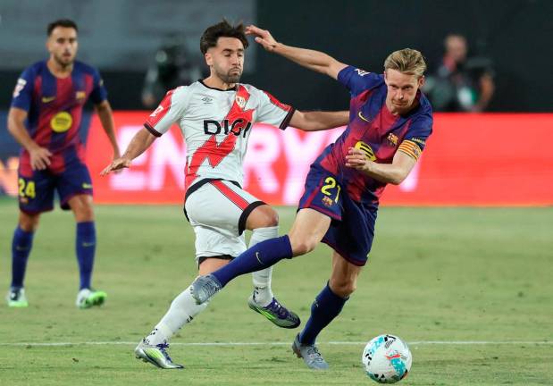 Rayo Vallecano’s midfielder Unai Lopez fights for the ball with Barcelona’s midfielder Frenkie De Jong during the Spanish league football match between Rayo Vallecano de Madrid and FC Barcelona at the Vallecas stadium in Madrid on August 31, 2025. - AFP