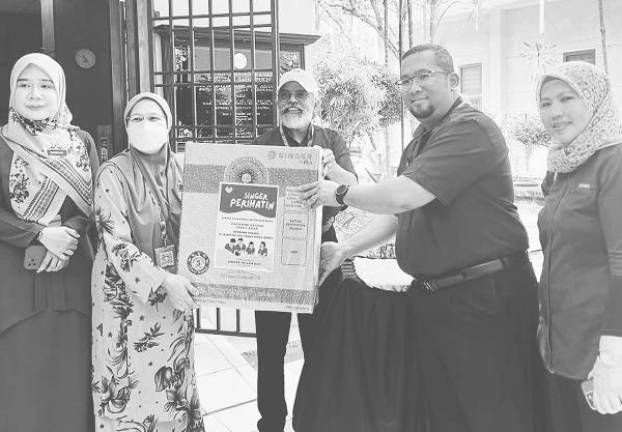 Prabakaran (centre) and Aizad Hizami (second from right) handing over a Singer stand fan to Zainah. – COURTESY PIC OF SINGER