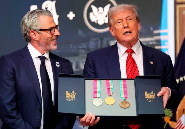 U.S. President Donald Trump, accompanied by LA28 Chairman Casey Wasserman, holds 1984 Los Angeles Olympics medals as he delivers remarks before signing an executive order to create a White House Olympics task force to handle security and other issues related to the LA 2028 Summer Olympics, in the South Court Auditorium on the White House campus in Washington. Reuterspix