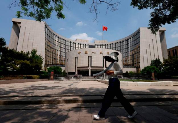 A person walks past the headquarters of the People’s Bank of China, in Beijing, China May 7, 2025. REUTERSpix