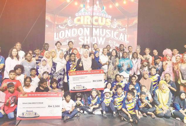 Children from the two homes and their chaperons with performers at the event. – T.C. KHOR /THESUN