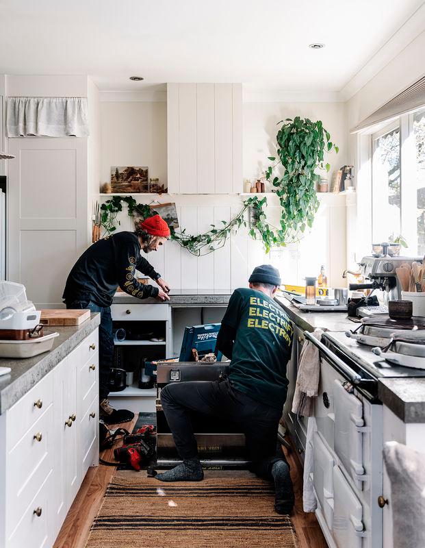 Electric appliances being installed in a bright, modern kitchen.