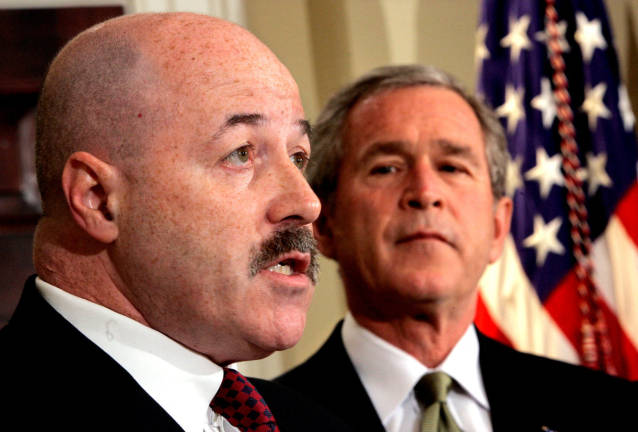 FILE PHOTO: U.S. President George W. Bush listens to remarks after he announced that former New York City police commissioner Bernard Kerik (L), who helped the city respond to the September 11, 2001, attacks and trained Iraqi police, will become the new homeland security secretary, December 3, 2004. REUTERS/Kevin Lamarque/File Photo
