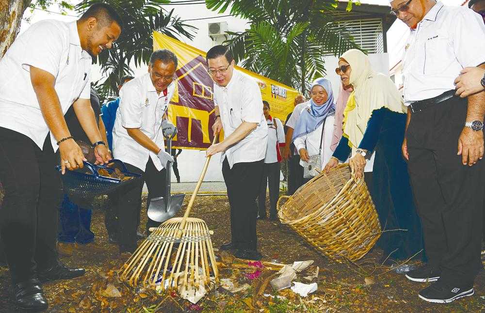 Lim (centre), who is also Bagan MP, participates in a gotong-royong campaign to clean up Taman Bagan Baru after launching the Kampungku Sihat programme on Sunday. – BERNAMAPIX