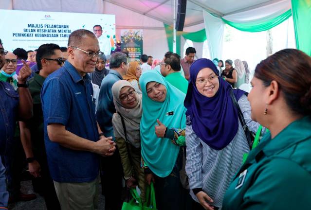 Menteri Kesihatan Datuk Seri Dr Dzulkefly Ahmad (kiri) beramah mesra bersama para tetamu yang hadir pada Majlis Sambutan Hari Kesihatan Mental Sedunia Peringkat Kebangsaan 2025 di Taman Tasik Cyberjaya hari ini. - Bernama