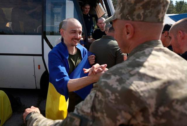 Ukrainian servicemen embrace fellow soldiers after being released from Russian captivity at an undisclosed location near the Ukrainian-Belarusian border, on September 13, 2024, amid the Russian invasion in Ukraine. 49 Ukrainian prisoners of war, including soldiers of the armed forces of Ukraine, the National Guard, the national police, the state border guard service, as well as fighters from Mariupol's 2022 Azvostal battle, had been returned to their country from Russia on September 13, 2024. - Anatolii STEPANOV / AFP