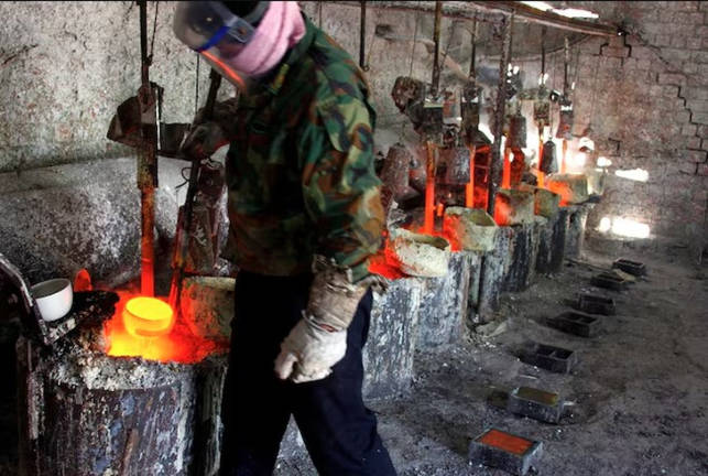 A worker at a smelting workshop prepares to pour the rare earth metal lanthanum into a mould near the town of Damao in China’s Inner Mongolia Autonomous Region, October 31, 2010. - REUTERS