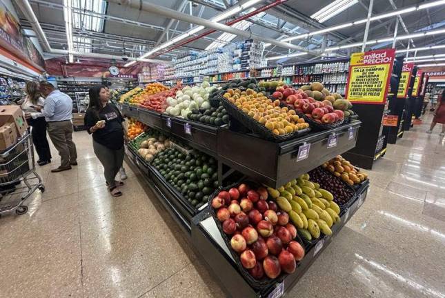 For representational purposes -A woman walks next to fruits and vegetables for sale in a supermarket in Mexico City on March 4, 2025. AFPpix