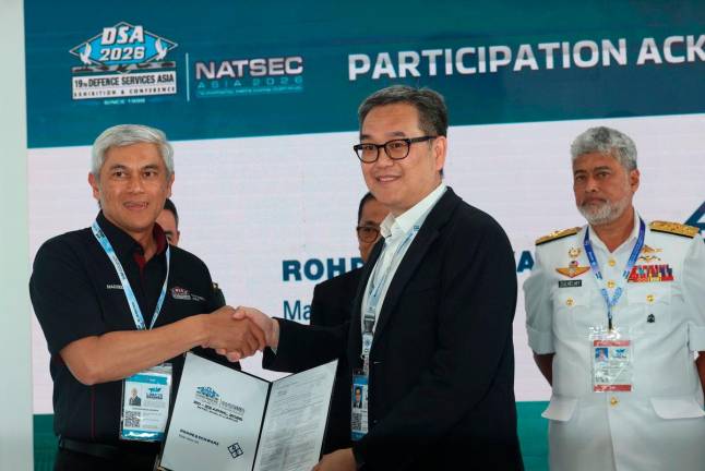 Minister of Defence, Datuk Seri Mohamed Khaled Nordin (second from left), witnesses the signing ceremony between DSA Executive Director Nadzeem Rahman (left) and Managing Director of Rohde &amp; Schwarz, Lee Choon Yu (second from right), during the event here in Langkawi. - BERNAMApix