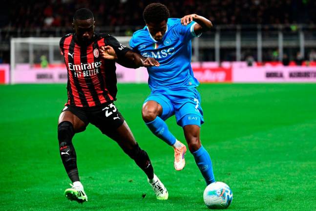 AC Milan’s defender Fikayo Tomori fights for the ball with Napoli’s forward David Neres (R) during the Italian Serie A football match between AC Milan and SSC Napoli at San Siro stadium in Milan, northern Italy, on September 28, 2025. - AFP
