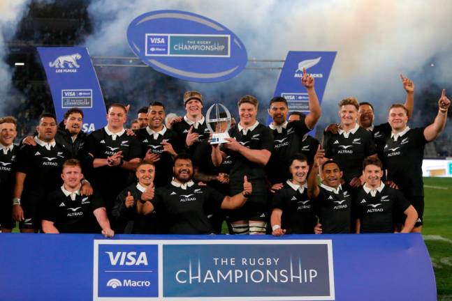 New Zealand’s All Blacks players pose with their trophy after winning the Rugby Championship 2025 match between Argentina and New Zealand at Mario Alberto Kempes stadium in Cordoba, Argentina - AFP