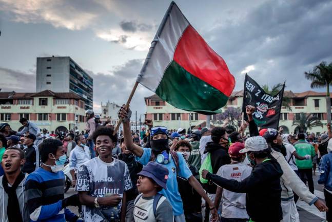 Protesters celebrate at Antananarivo City Hall after listening the address of members of a section of the Malagasy army following clashes between demonstrators and security forces during protests calling for the resignation of President Andry Rajoelina in Antananarivo, on October 11, 2025. - AFP