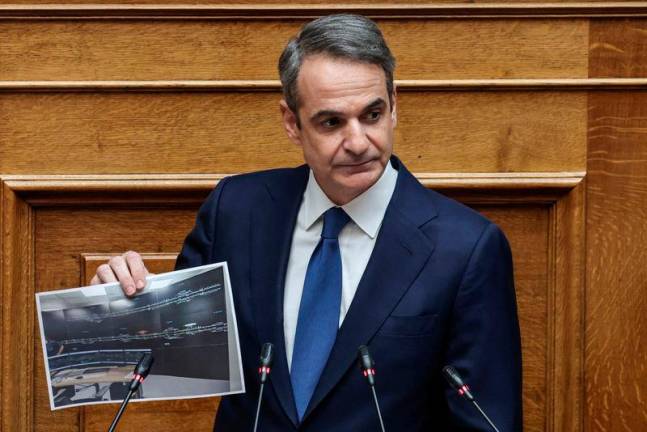 Greek Prime Minister Kyriakos Mitsotakis shows a picture during a debate on a 2023 train crash that killed 57 people, at the Greek parliament in Athens, Greece, REUTERSpix