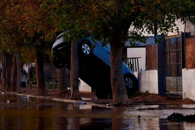 A car leans precariously against a wall after severe flooding in Utiel, Spain, October 30, 2024. REUTERS/Susana Vera