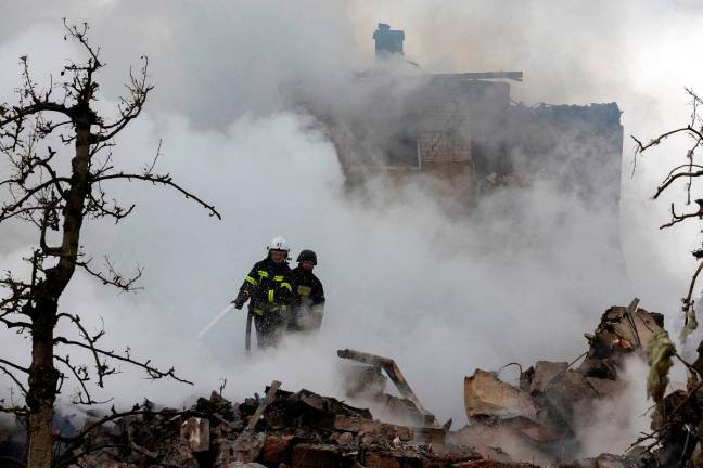 Emergency workers extinguish fire in the debris of a private house that was destroyed in a Russian rocket strike, amid Russia’s attack on Ukraine, in Markhalivka, Kyiv region, Ukraine, May 25, 2025. - REUTERS/Thomas Peter