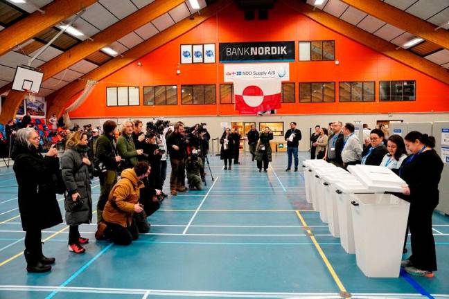 People stand near ballot boxes which are ready for the first votes to be cast in the parliamentary election for the Inatsisartut in Godthaabshallen, on the day of the general election, in Nuuk, Greenland, March 11, 2025. REUTERSpix