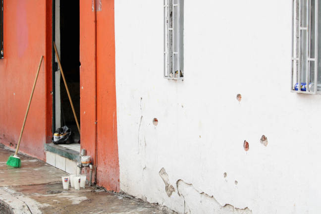 Votive candles are placed near the bullet-riddled house where gunmen opened fire on Tuesday during a party celebrating the Nativity of John the Baptist, leaving several casualties, in Irapuato, Guanajuato state, Mexico June 25, 2025. - REUTERS