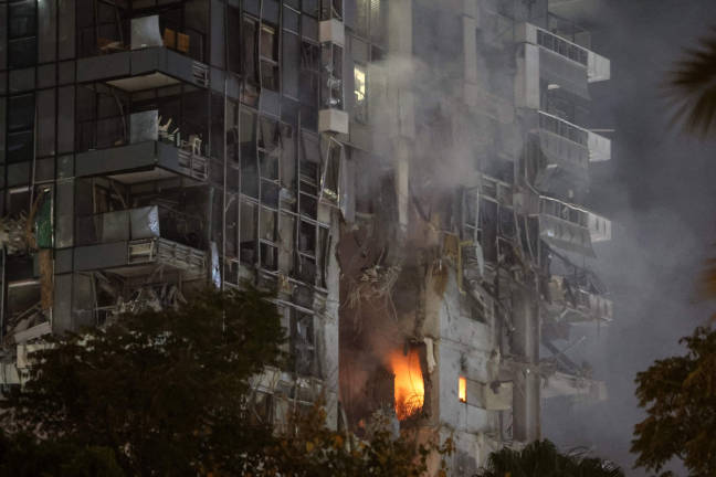 Fire and smoke rise from a building, reportedly hit by a missile fired from Iran, in central Tel Aviv on June 13, 2025. - AFPpix