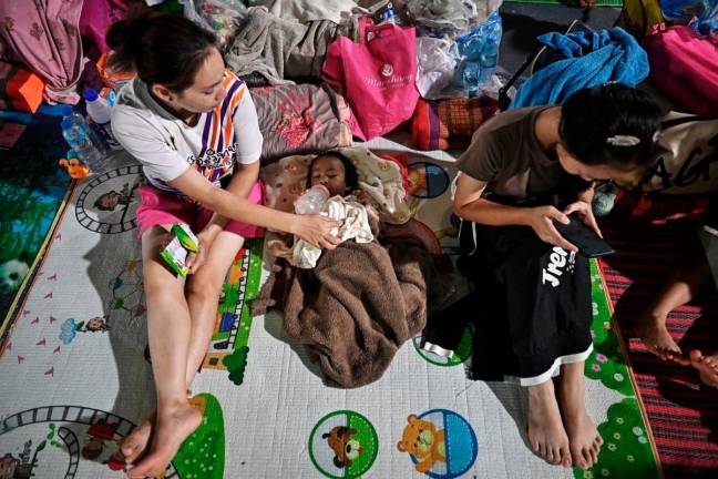 Evacuees displaced by the ongoing conflict between Thailand and Cambodia rest at an evacuation center in the Thai border province of Si Sa Ket on July 26, 2025. -AFP