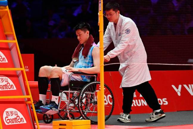 Malaysia’s Lee Zii Jia is pushed off the court in a wheelchair after an injury during his men’s singles match against China’s Li Shifeng at the BWF Badminton World Tour Finals in Hangzhou, in eastern China’s Zhejiang province on December 13, 2024. - AFPpix