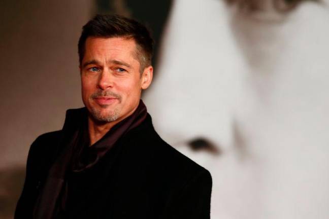 US actor Brad Pitt poses for photographers after arriving to attend the UK premiere of the film ‘Allied’ in Leicester Square, central London on November 21, 2016. / AFP / Adrian DENNIS